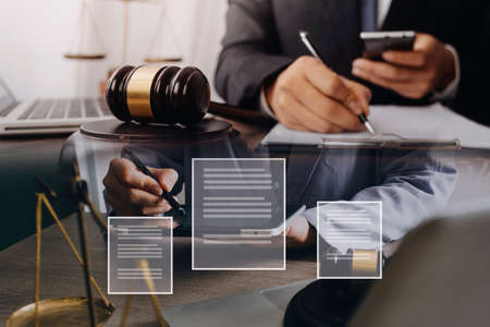 Male lawyer working with contract papers and wooden gavel on tabel in courtroom. justice and law...