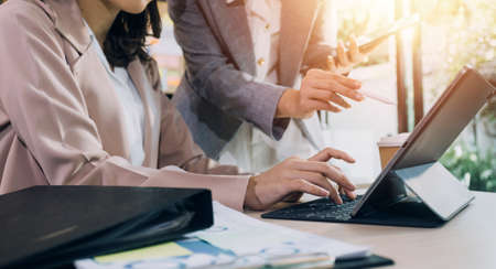 Woman accountant use calculator and computer with holding pen on