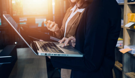 Woman accountant use calculator and computer with holding pen on