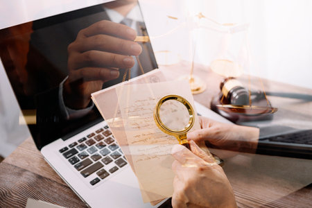 Business and lawyers discussing contract papers with brass scale on desk in office. Law, legal services, advice, justice and law concept picture with film grain effectの写真素材