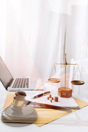 Business and lawyers discussing contract papers with brass scale on desk in office. Law, legal services, advice, justice and law concept picture with film grain effectの写真素材