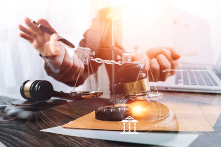 Business and lawyers discussing contract papers with brass scale on desk in office. Law, legal services, advice, justice and law concept picture with film grain effectの写真素材