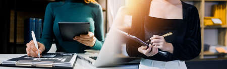 Woman accountant use calculator and computer with holding pen on