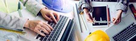 Two colleagues discussing data working and tablet, laptop with on on architectural project at...