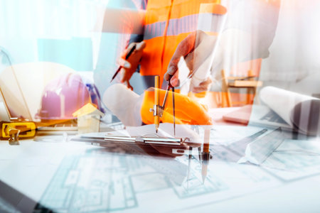 business hand working and laptop with on on architectural project at construction site at office...