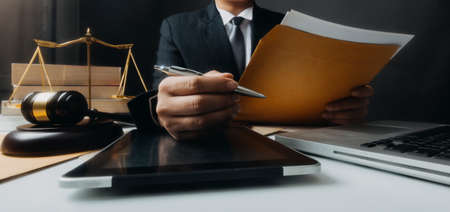 Justice and law concept.Male judge in a courtroom with the gavel, working with, computer and docking...