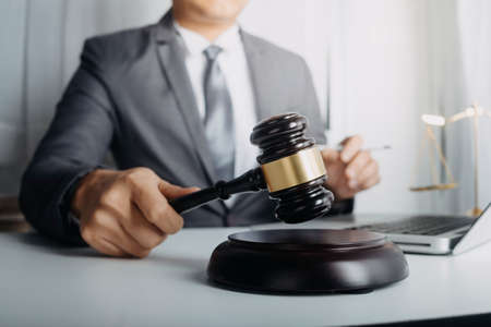 Justice and law concept.Male judge in a courtroom with the gavel, working with, computer and docking...