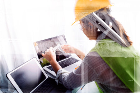 Two colleagues discussing data working and tablet, laptop with on on architectural project at...