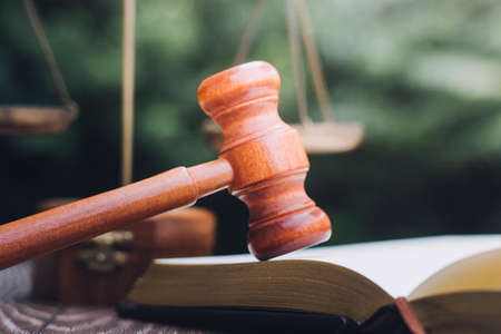 Business and lawyers discussing contract papers with brass scale on desk in office. Law, legal services, advice, justice and law concept picture with film grain effectの写真素材