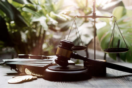 Business and lawyers discussing contract papers with brass scale on desk in office. Law, legal services, advice, justice and law concept picture with film grain effectの写真素材