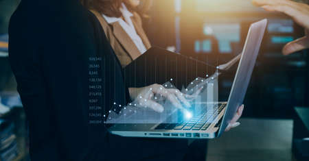 Businessman with a tablet in his hand And touching on the screen That shows a business graph. The concept of starting a new business that goes better.の写真素材