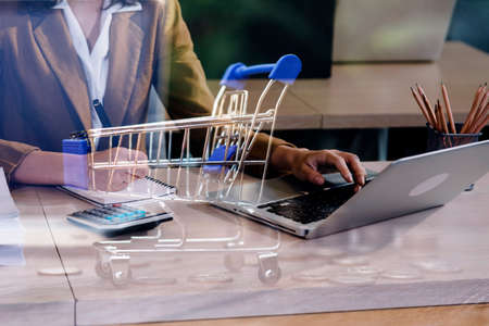Woman accountant use calculator and computer with holding pen on