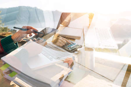 Woman accountant use calculator and computer with holding pen on