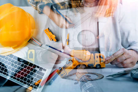 business hand working and laptop with on on architectural project at construction site at office...