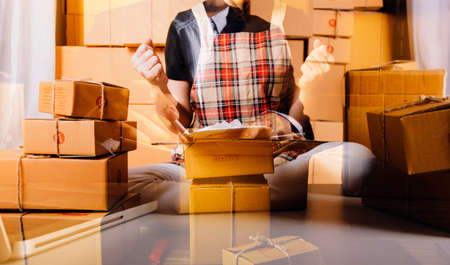 Young woman small business owner online shopping at home. taking note of orders from customers with...