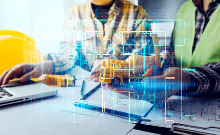 Two colleagues discussing data working and tablet, laptop with on on architectural project at...