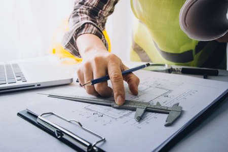 Two colleagues discussing data working and tablet, laptop with on on architectural project at...