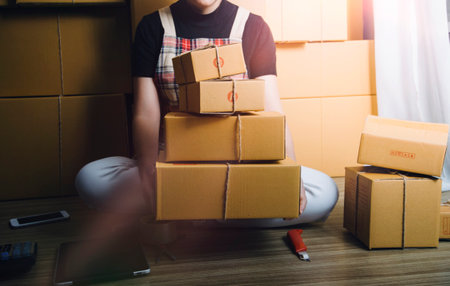 Young woman small business owner online shopping at home. taking note of orders from customers with...