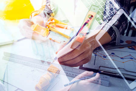 business hand working and laptop with on on architectural project at construction site at office...