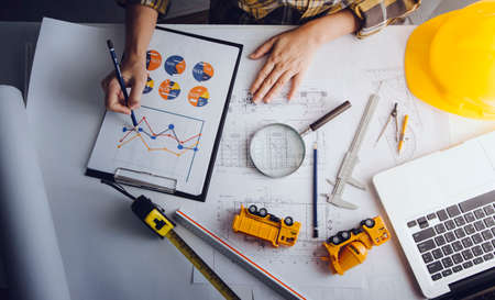Two colleagues discussing data working and tablet, laptop with on on architectural project at...