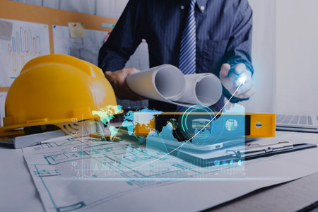business hand working and laptop with on on architectural project at construction site at office...