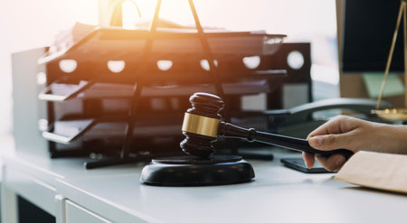 Male lawyer working with contract papers and wooden gavel on tabel in courtroom. justice and law...