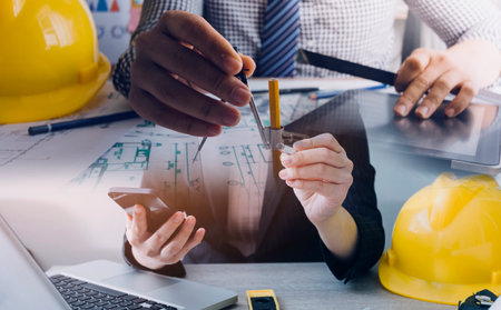 Construction engineer working at blueprint to build large commercial buildings in office....