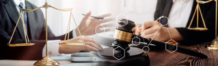 Justice and law concept.Male judge in a courtroom with the gavel, working with, computer and docking keyboard, eyeglasses, on table in morning lightの写真素材