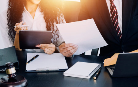 justice and law concept.Male judge in a courtroom on wooden table and Counselor or Male lawyer working in office. Legal law, advice and justice concept.の写真素材