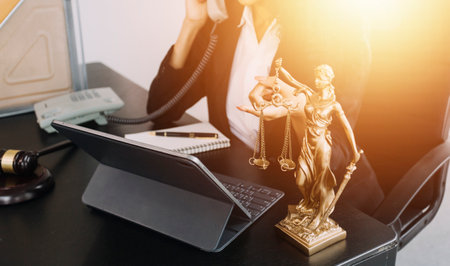 justice and law concept.Male judge in a courtroom on wooden table and Counselor or Male lawyer working in office. Legal law, advice and justice concept.の写真素材