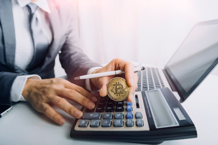 Woman entrepreneur using a calculator with a pen in her hand, calculating financial expense at home officeの写真素材