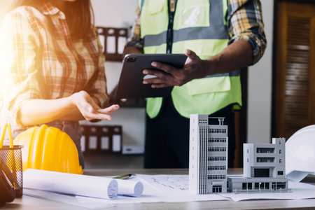 Construction engineer working at blueprint to build large commercial buildings in office....