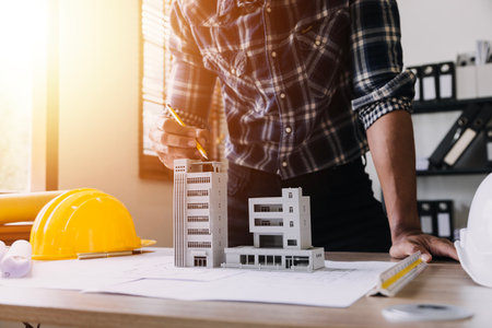 Construction engineer working at blueprint to build large commercial buildings in office....