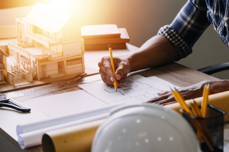Construction engineer working at blueprint to build large commercial buildings in office....