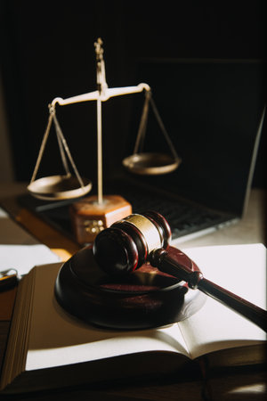 law books and scales of justice on desk in library of law firm. jurisprudence legal education...