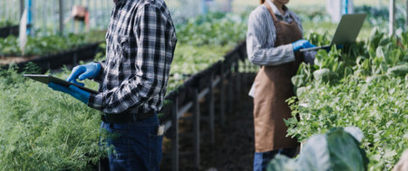 female farmer working early on farm holding wood basket of fresh vegetables and tablet