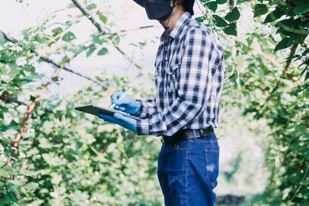 Futuristic businessman farms vegetables and crops using modern AI technology using mobile phones,...
