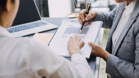 law books and scales of justice on desk in library of law firm. jurisprudence legal education concept.の写真素材