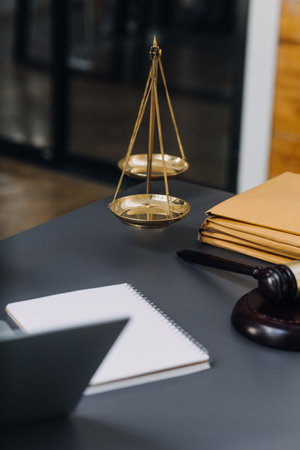 Justice and law concept.Male judge in a courtroom with the gavel, working with, computer and docking keyboard, eyeglasses, on table in morning lightの写真素材