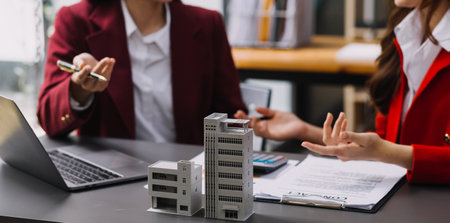 Discussion with a real estate agent, House model with agent and customer discussing for the contract to buy, get insurance or loan real estate or property.の写真素材