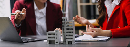 Discussion with a real estate agent, House model with agent and customer discussing for the contract to buy, get insurance or loan real estate or property.の写真素材