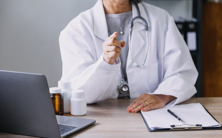Homecare nursing service and elderly people cardiology healthcare. Close up of young hispanic female doctor nurse check mature caucasian man patient heartbeat using stethoscope during visitの写真素材