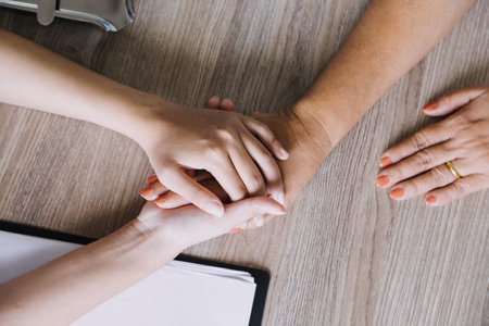 Homecare nursing service and elderly people cardiology healthcare. Close up of young hispanic female doctor nurse check mature caucasian man patient heartbeat using stethoscope during visitの写真素材