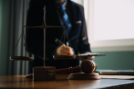 Business and lawyers discussing contract papers with brass scale on desk in office. Law, legal services, advice, justice and law concept picture with film grain effectの写真素材