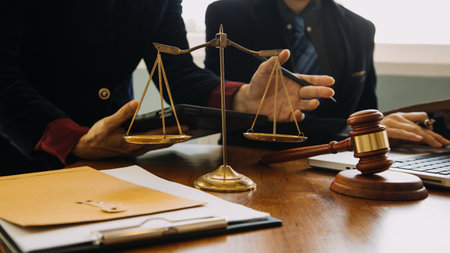 Business and lawyers discussing contract papers with brass scale on desk in office. Law, legal services, advice, justice and law concept picture with film grain effectの写真素材