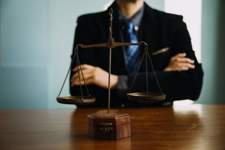 Business and lawyers discussing contract papers with brass scale on desk in office. Law, legal services, advice, justice and law concept picture with film grain effectの写真素材