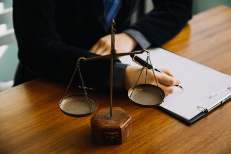 Business and lawyers discussing contract papers with brass scale on desk in office. Law, legal services, advice, justice and law concept picture with film grain effectの写真素材