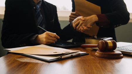 Business and lawyers discussing contract papers with brass scale on desk in office. Law, legal services, advice, justice and law concept picture with film grain effectの写真素材
