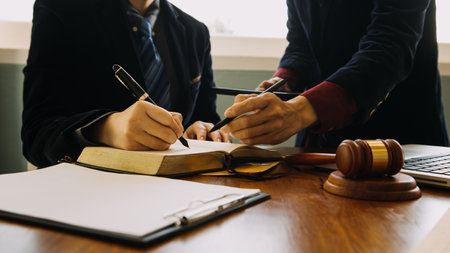 Business and lawyers discussing contract papers with brass scale on desk in office. Law, legal services, advice, justice and law concept picture with film grain effectの写真素材
