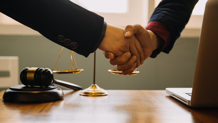 Business and lawyers discussing contract papers with brass scale on desk in office. Law, legal services, advice, justice and law concept picture with film grain effectの写真素材